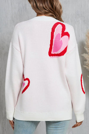 White acrylic sweater with intarsia heart motif pattern and crew neck.