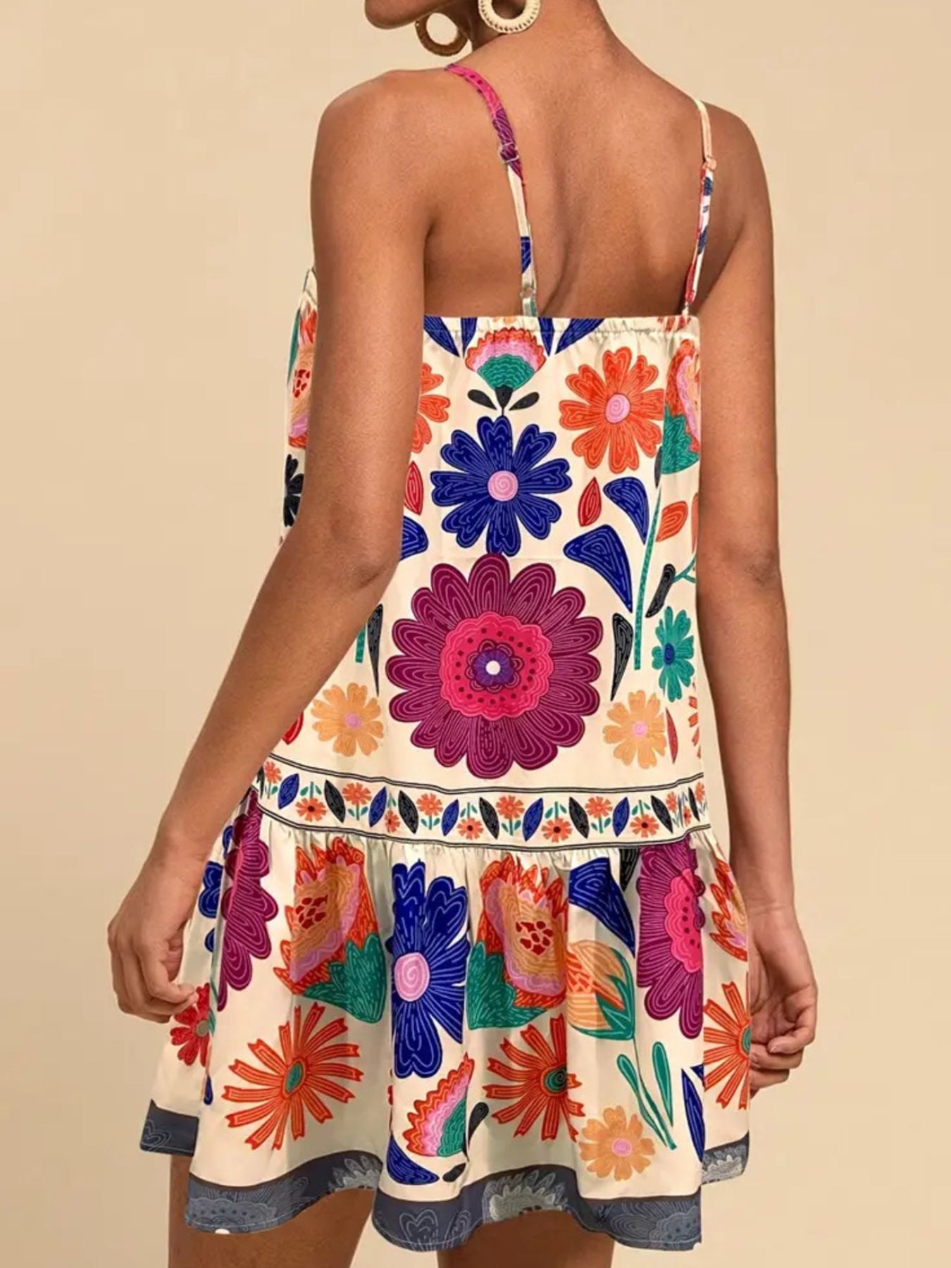 Vibrant floral print mini dress with spaghetti straps and tiered skirt.
