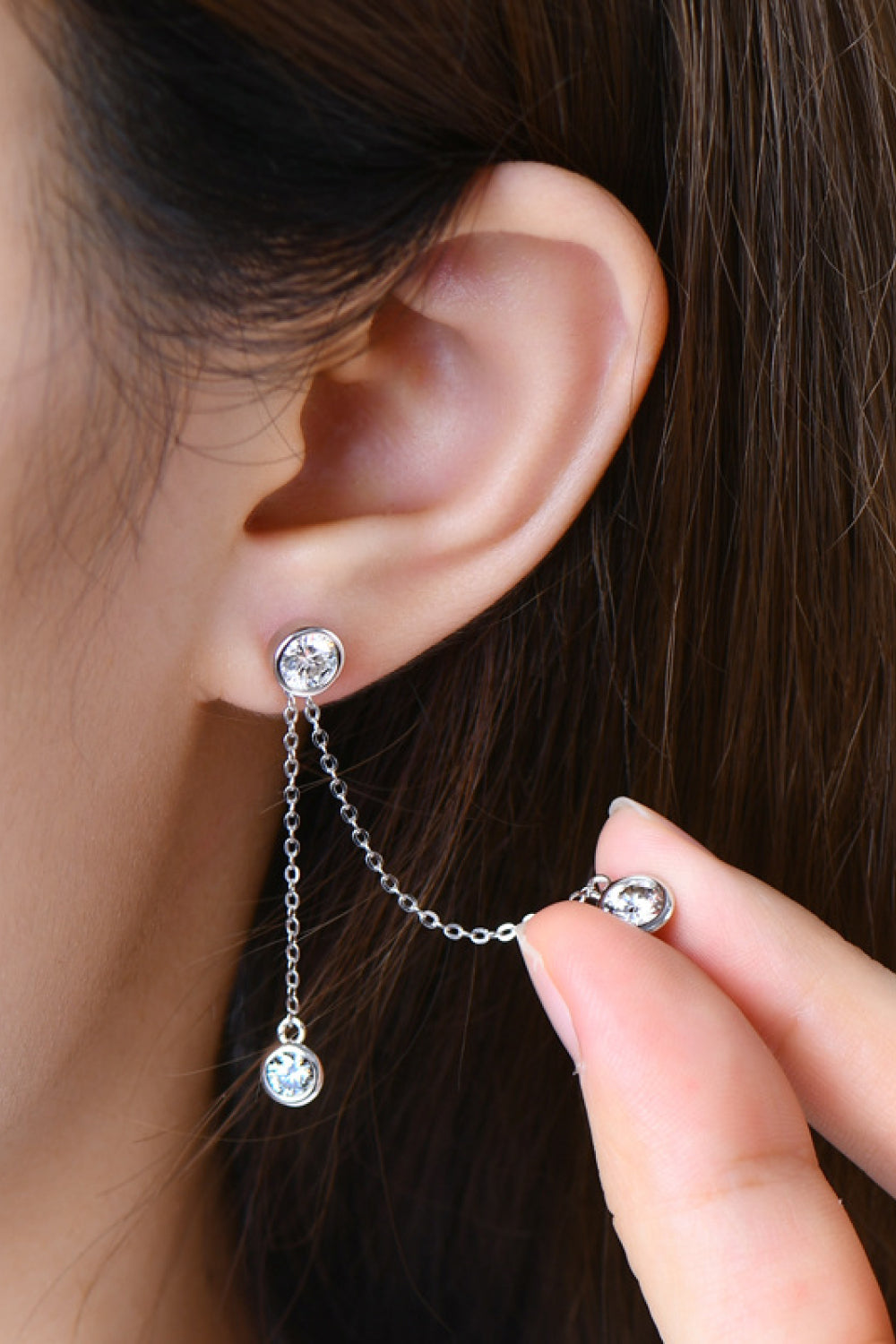Silver cascade diamond drop earrings with chain detail and two dangling stones.