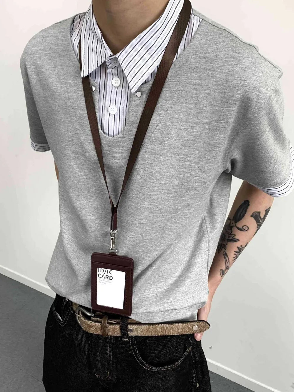 Gray layered polo with striped collar and button placket, cotton blend.