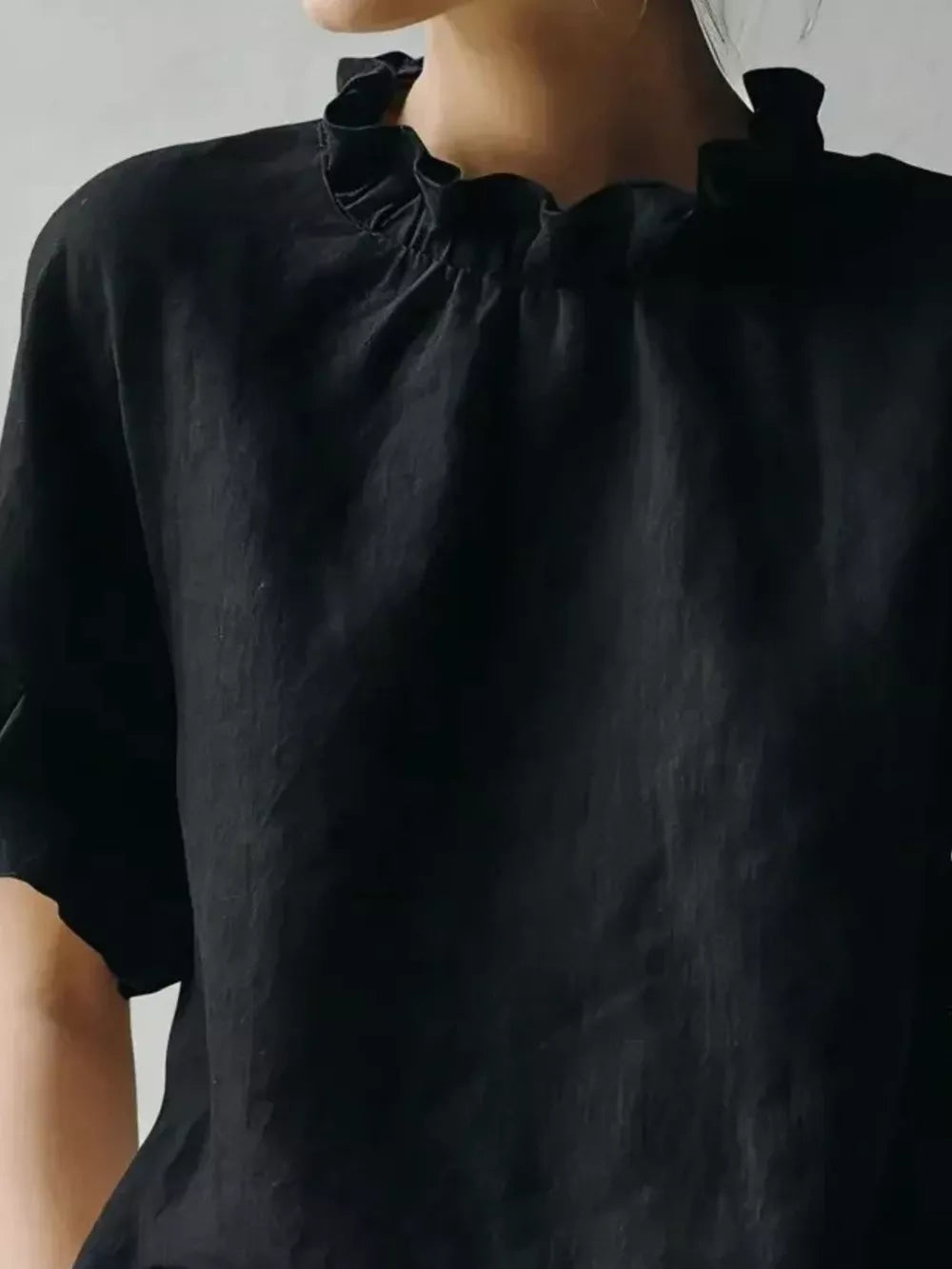 Black half-sleeve shirt with ruffled neckline detail