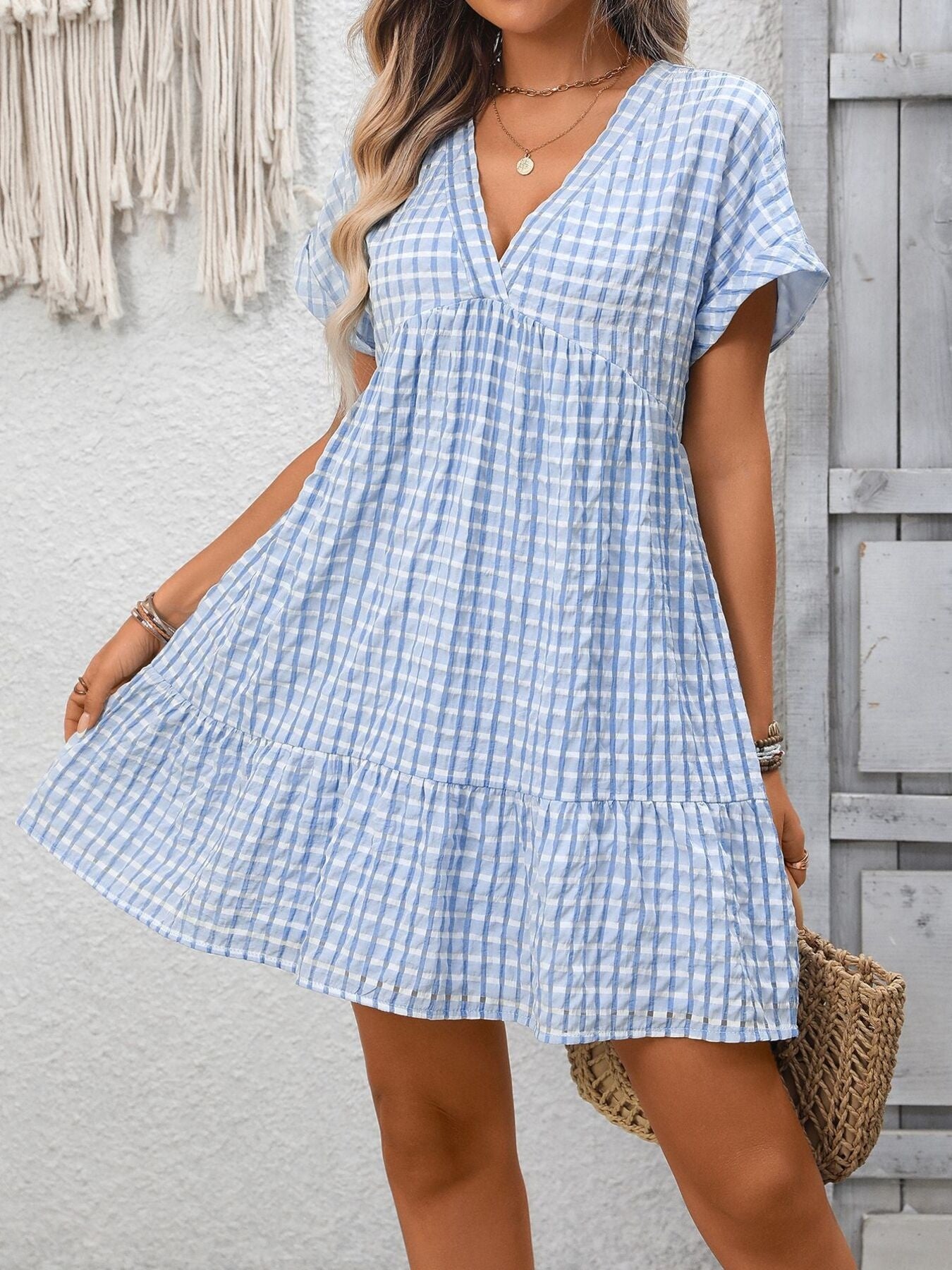 Light blue plaid V-neck mini dress with short sleeves and tiered hem.