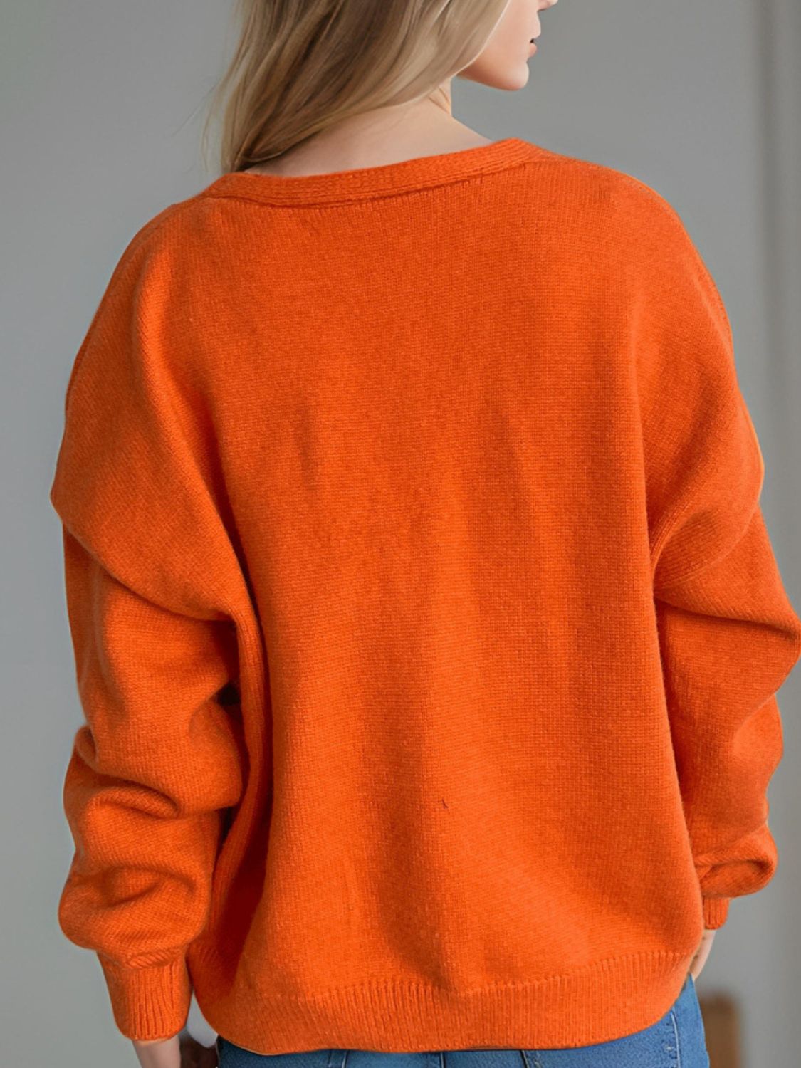 Orange acrylic oversized knit cardigan with crew neck and long sleeves