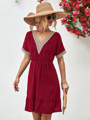 Burgundy A-line dress with Swiss dot texture, crochet trim V-neck, short sleeves, and tiered hem.