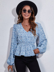 Floral peplum blouse with gathered waist and V-neck in blue.