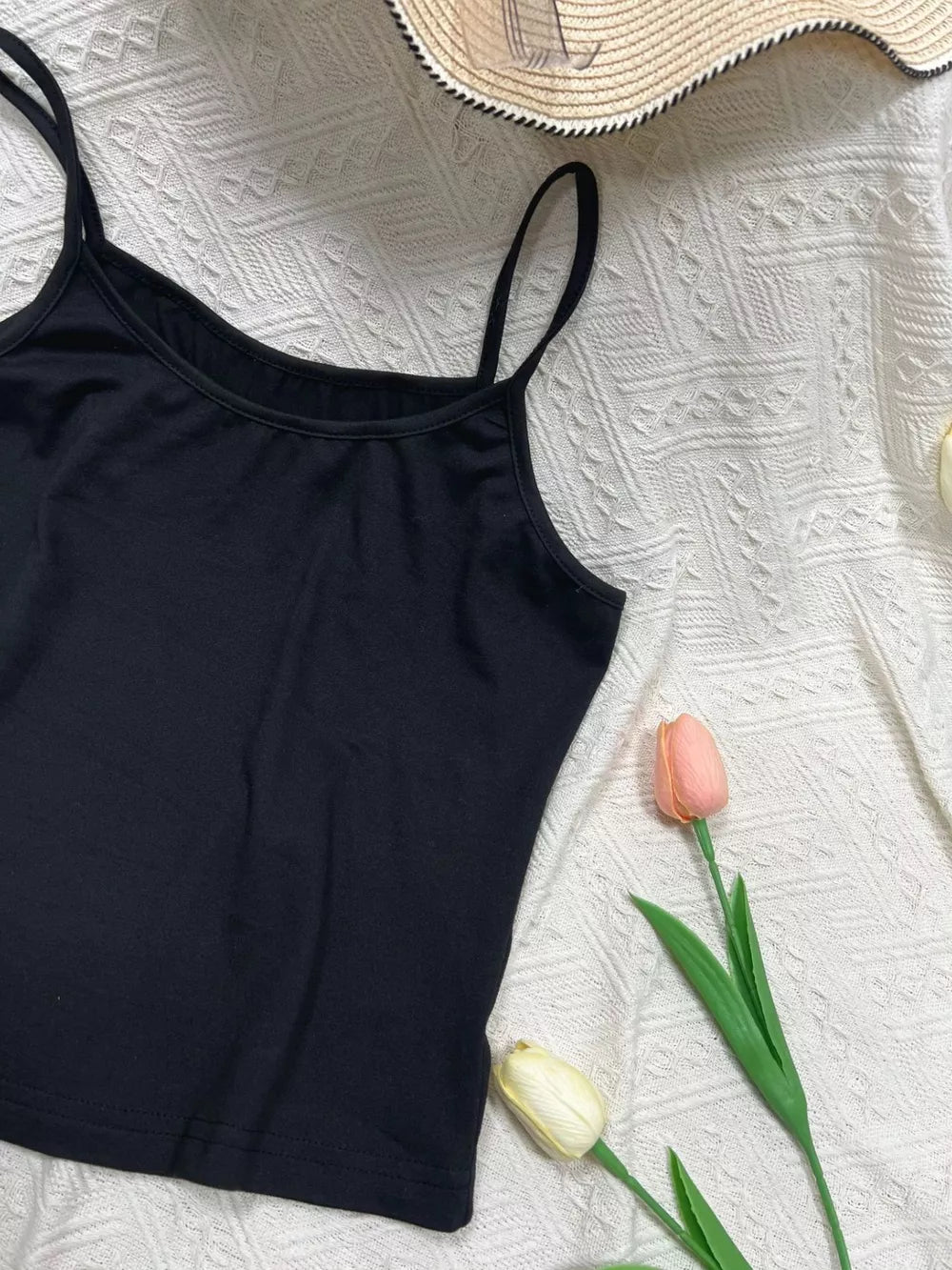 Black cami top with scoop neck and adjustable spaghetti straps.