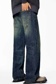 Men's wide-leg jeans in vintage wash blue denim with distressed details.