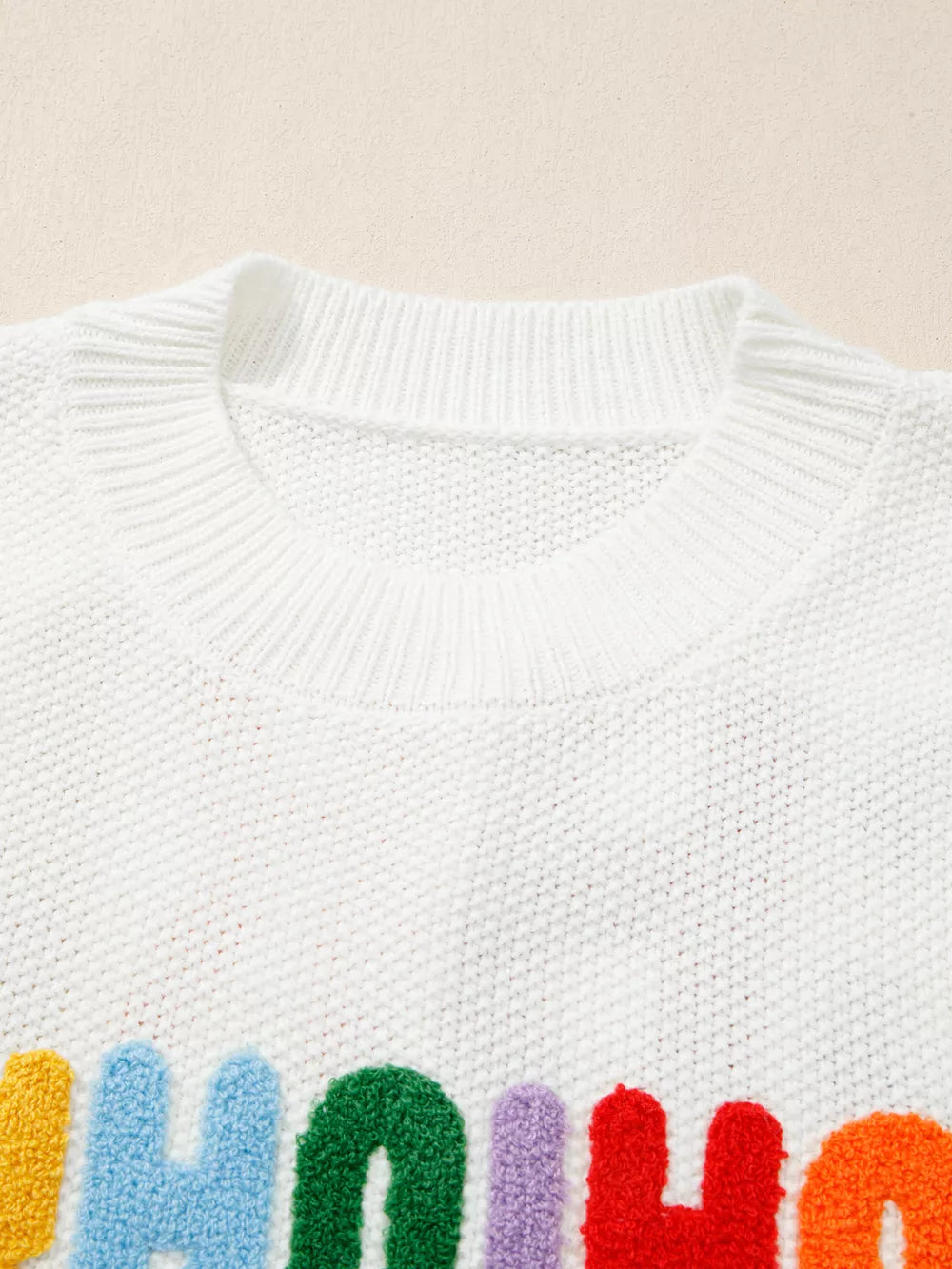 White chenille chunky knit crew neck sweater with colorful fuzzy letters.