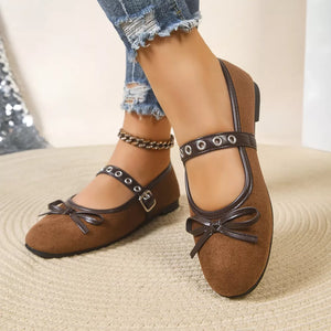 Brown Mary Jane flats with bow detail and buckle strap with eyelets.