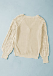 Cream diamond-cut sleeve knit cardigan with ribbed cuffs and neckline.