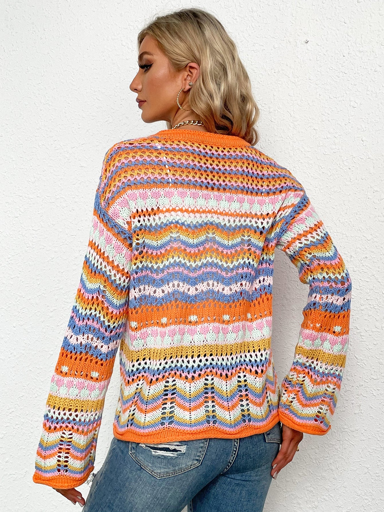 Rainbow chevron knit cardigan with openwork detail and orange trim.