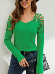 Green ribbed knit blouse with cold shoulder cutouts and sequin embellishments on the sleeves.