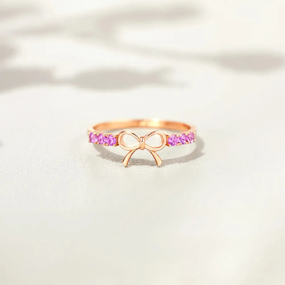 Rose gold ring with bow detail and pink gemstones