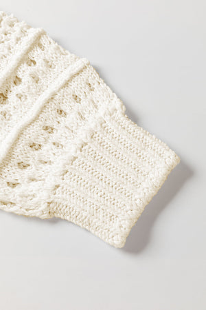 Ivory openwork knit sweater with balloon sleeves and textured details.