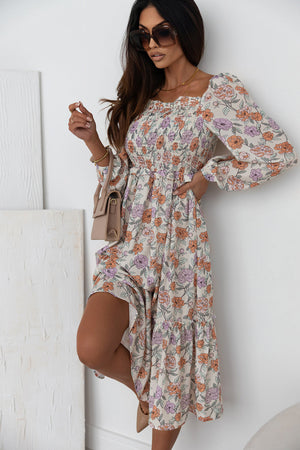 Floral midi dress with shirred bodice, square neckline, long sleeves, and tiered hem.