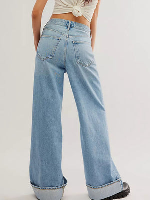 Light blue denim wide-leg trousers with large cuffs, shown from the back.