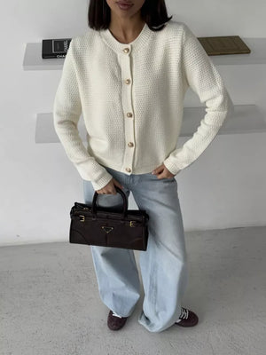 Textured knit cardigan in white with elegant gold button detail and crew neck.