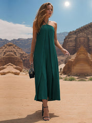 Dark green draped halter jumpsuit with palazzo legs and front slit detail