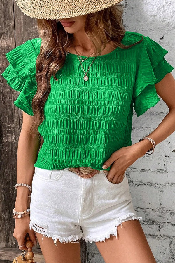 Green crew neck top with textured smocking and ruffled cap sleeves.