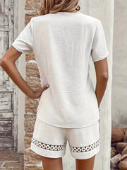 White lace-trimmed shorts with textured fabric and circular cutouts on the hem.