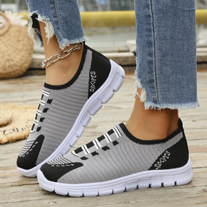 Mesh slip-on sneakers in grey and black with white soles and "Sports" detail.