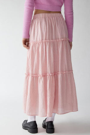 Tiered cotton maxi skirt in blush pink with ruffled tiers.