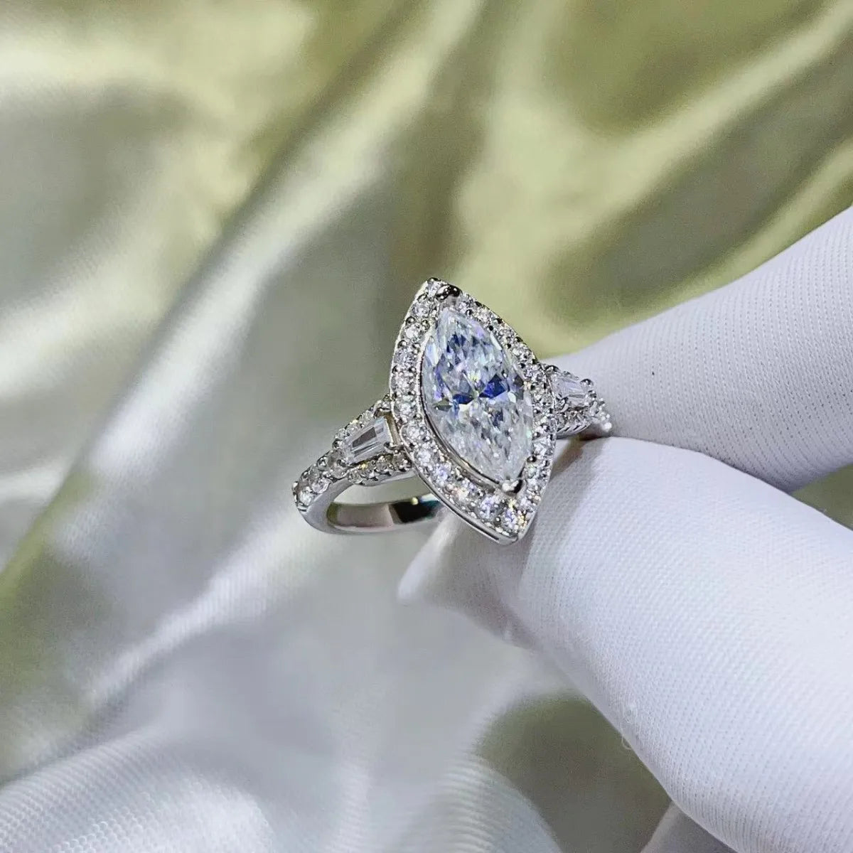 White gold marquise halo moissanite engagement ring with baguette and round accent stones.