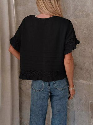 Black knit top with crew neck, short sleeves, and delicate lace trim at cuffs and hem.