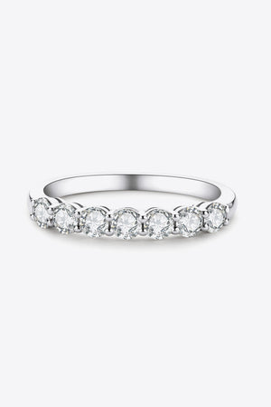 Silver band ring with seven round moissanite stones in a shared prong setting.