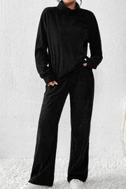 Black corduroy turtleneck loungewear set with long sleeves and wide-leg pants.