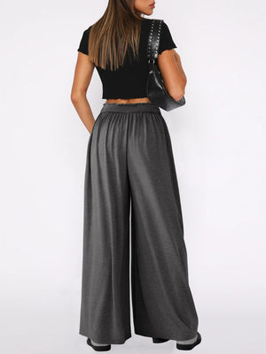 Drape-front wide-leg jersey trousers in dark gray with elastic waistband.