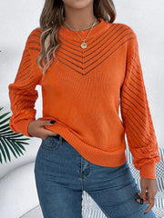 Orange openwork chevron knit sweater with blouson sleeves and mock neckline.