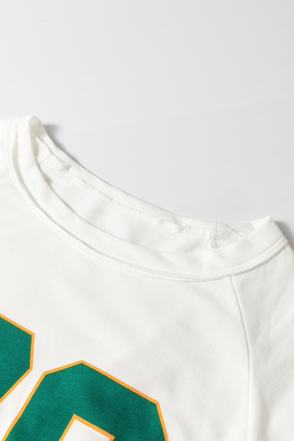 White raglan sleeve sweatshirt with green and yellow varsity number detail