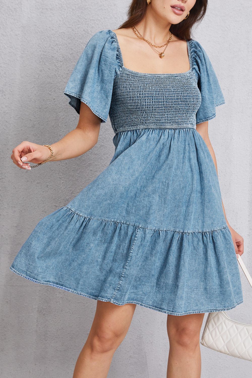 Light blue denim prairie dress with smocked bodice and puff sleeves.