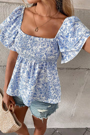 Floral ruffled sleeve babydoll shirt with smocked bodice and square neckline.
