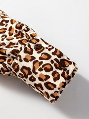 Leopard print button-down shirt cuff with two brown buttons and frilled trim detail.