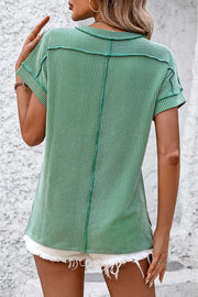 Green vertical ribbed tee with split hem and short sleeves.