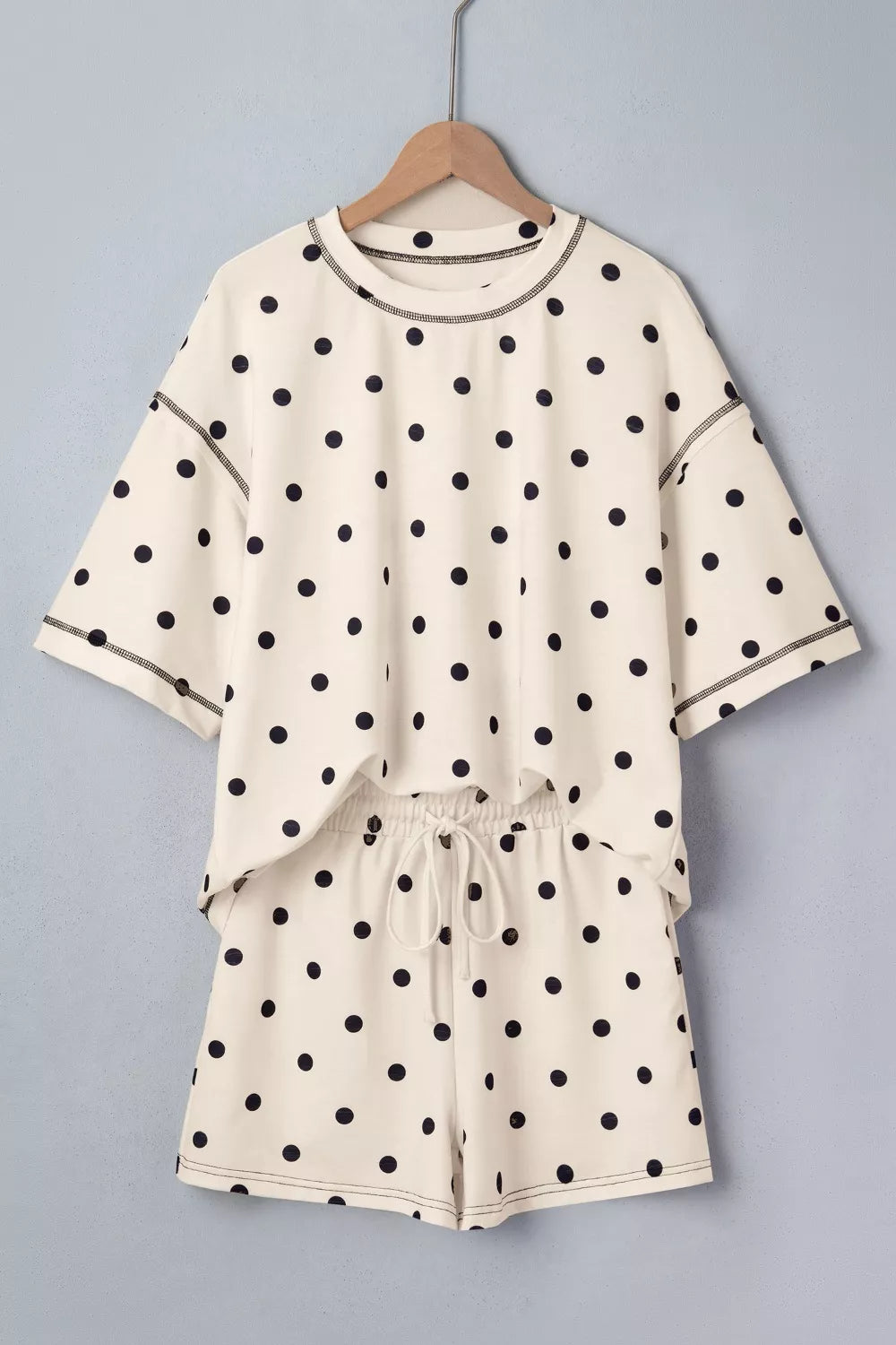 Cream polka dot polyester two-piece set with drawstring shorts and crew neck top.