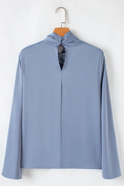 Dusty blue blouse with draped neckline, bell sleeves, and back keyhole with button closure.