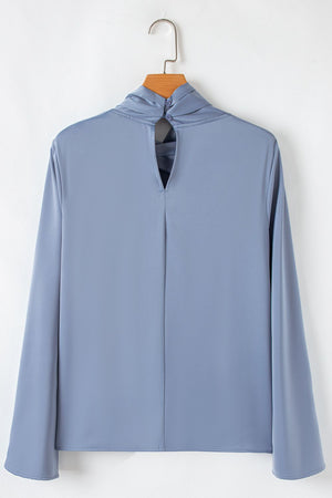 Dusty blue blouse with draped neckline, bell sleeves, and back keyhole with button closure.