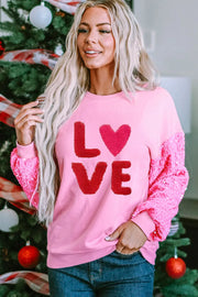 Pink sweatshirt with red sequin sleeves and "LOVE" appliqué.