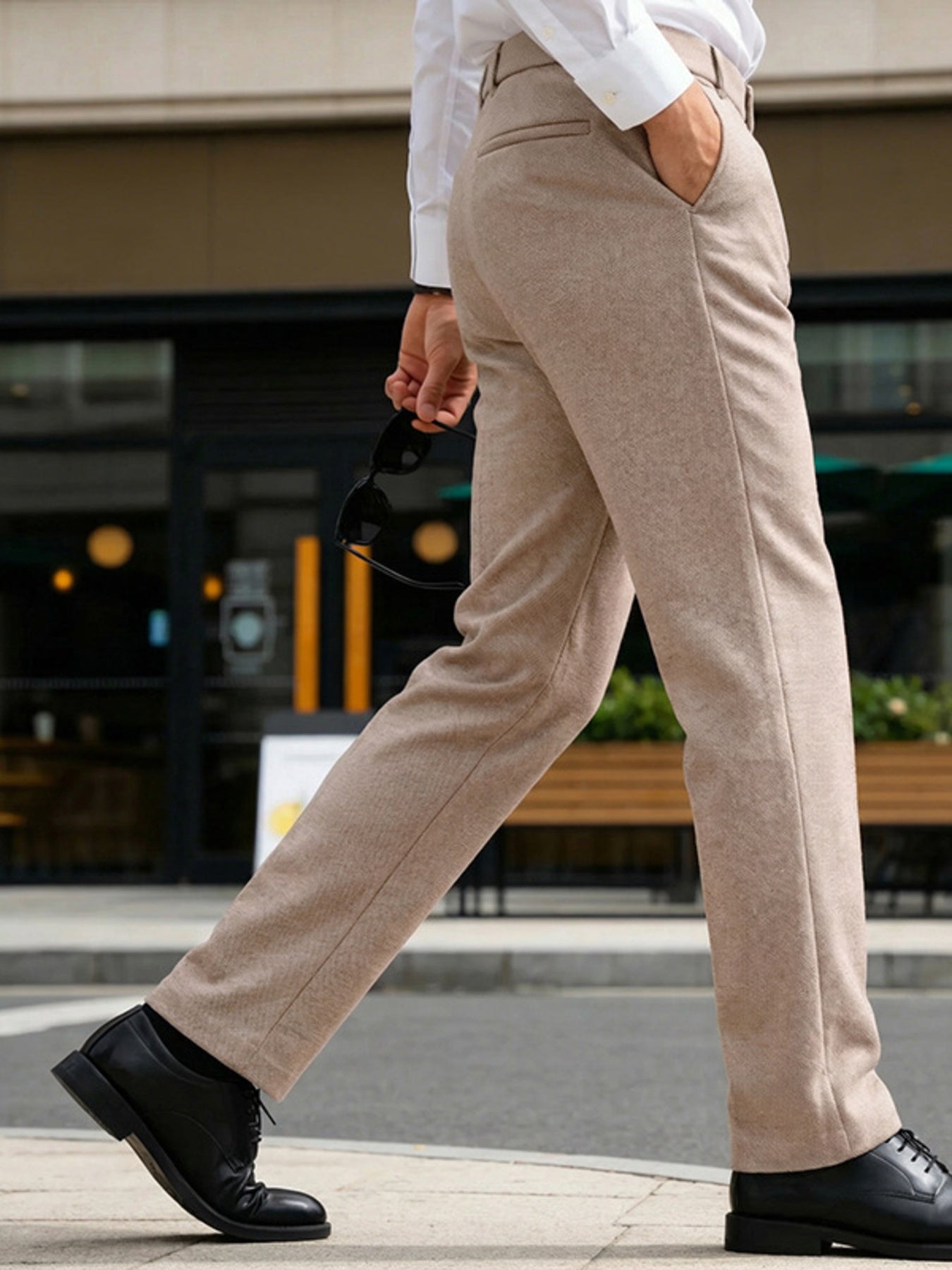 Classic fit men's khaki dress pants with pockets, shown with a white shirt and black shoes.