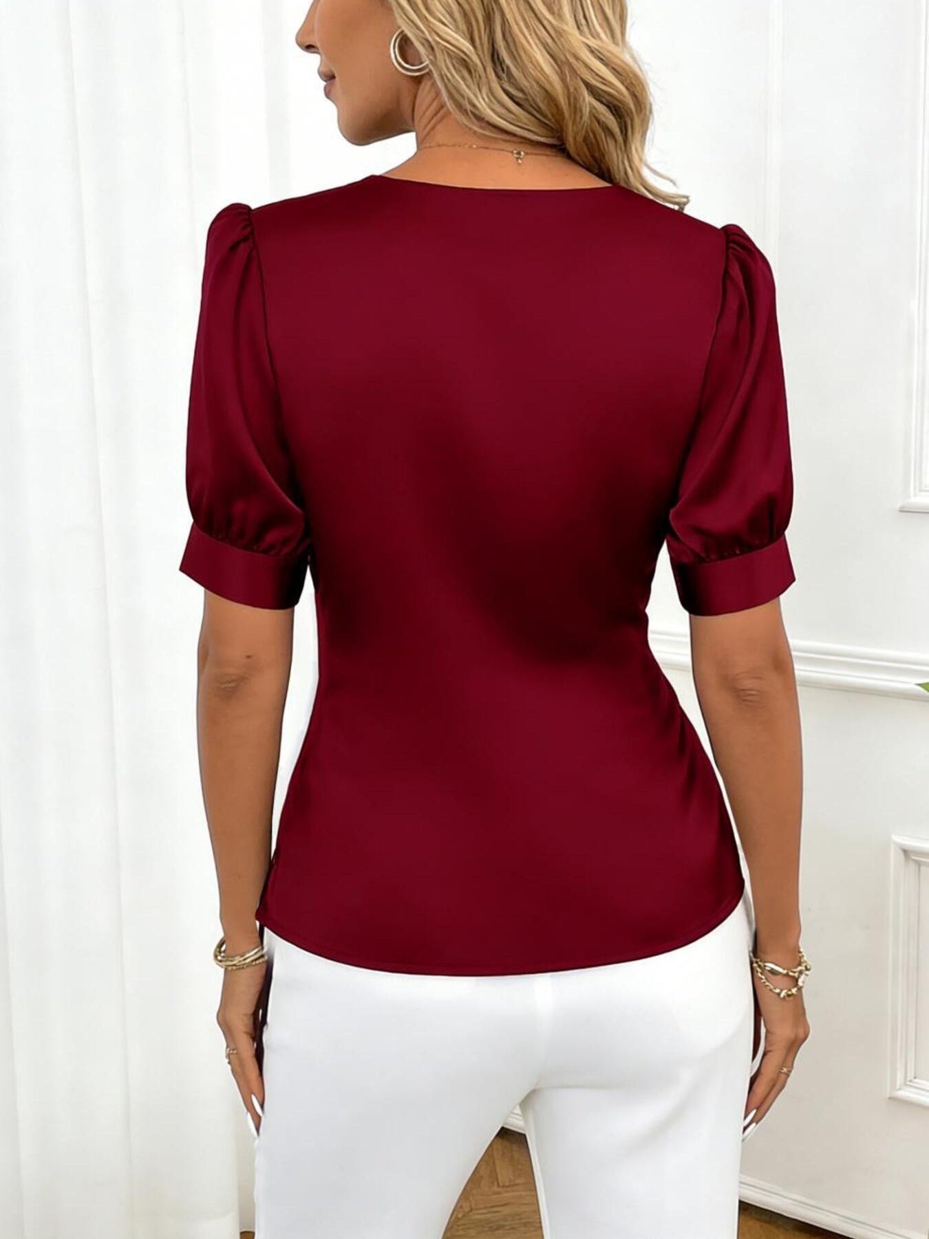 Burgundy satin wrap blouse with puff sleeves and a V-neckline.
