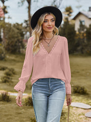 Blush pink textured blouse with lace trim neckline and ruffled cuffs.