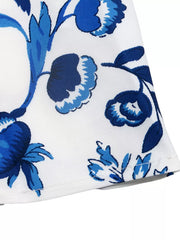 Floral halter neck mini dress with blue floral print on white fabric.