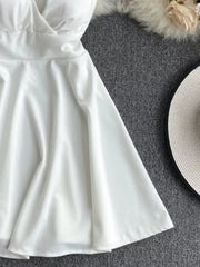 White spaghetti strap mini dress with V-neck and adjustable straps.