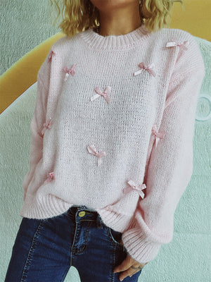 Blush pink knit crewneck sweater with allover satin bow embellishments.