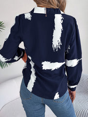 Dark blue collared blouse with white brushstroke print, long sleeves, and puff shoulders.