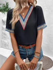 Black V-neck top with colorful embroidered trim on neckline and sleeves