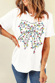 White t-shirt with a colorful holiday light bow graphic and "in my merry era" text.